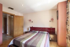 a bedroom with a bed with a striped blanket at Apartamentos Y Posada El Cafetal in Polanco