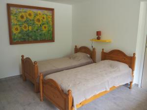 zwei Betten in einem Zimmer mit einem Gemälde an der Wand in der Unterkunft Clairefont in Castelsarrasin