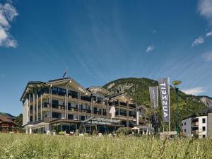 un bâtiment d'hôtel avec une montagne en arrière-plan dans l'établissement Hotel Auszeit, à Pertisau