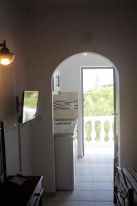 een keuken met een boog die leidt naar een patio bij Rodis Studios in Tsilivi