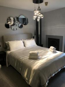 1 dormitorio con 1 cama grande y toallas. en The Chequers Inn, en Smarden