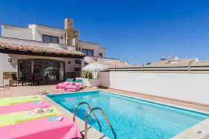 basen ze stołami i krzesłami obok domu w obiekcie Villa Ola by Villa Plus w Corralejo
