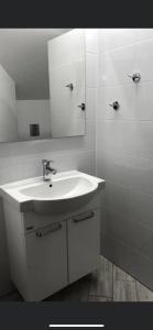 a white bathroom with a sink and a mirror at Siódme Niebo-komfortowe pokoje nad samym morzem in Stegna +19 photos