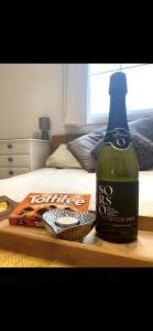 een fles wijn op een tafel naast een bed bij Romantic hideaway, seconds away from Perran beach in Perranporth