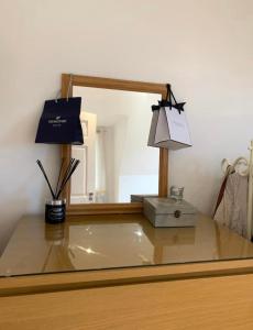 een bureau met een spiegel, een doos en een lamp bij Romantic hideaway, seconds away from Perran beach in Perranporth