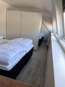 ein kleines Schlafzimmer mit einem Bett und einer Treppe in der Unterkunft Comfortabele woning mét omheinde tuin aan water voor 12 p in Oostburg