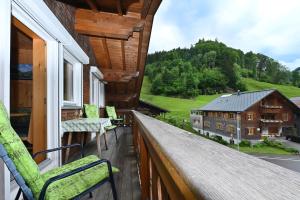 einen Balkon mit Stühlen und Blick auf ein Haus in der Unterkunft Appartements Willi in Schoppernau