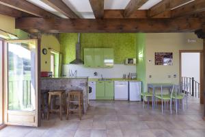 Apartamentos Y Posada El Cafetal في Polanco: مطبخ بجدران خضراء وطاولة وكراسي