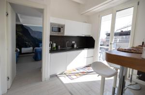 a kitchen with white cabinets and a table and a chair at Apartment Vesuvius in SantʼAntonio Abate