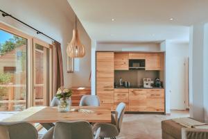 a dining room with a table and a kitchen at Chalet Resort Seenland in Steinberg