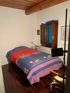1 dormitorio con 1 cama con manta roja y azul en Casa Musa, en Capannori