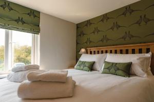 Aldringham的住宿－Knodishall - Newly renovated 2 bed holiday home, near Aldeburgh, Leiston and Thorpeness，一间卧室配有带毛巾的床