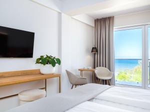 a hotel room with a bed and a view of the ocean at Resort Król Plaza Spa & Wellness in Jarosławiec