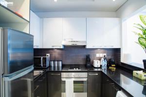 a kitchen with black counter tops and white cabinets at bnbme homes - Classic Studio Heart of the Marina - 808 in Dubai