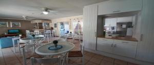 a kitchen and dining room with two tables and chairs at Dolphin Inn Blouberg in Bloubergstrand