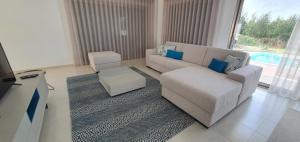 una sala de estar con un sofá y una mesa en Villa Silver Coast, en Nadadouro