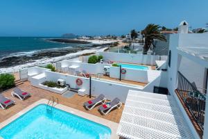 a view of the pool and the beach from a building at Villa Isabella by Villa Plus in Corralejo