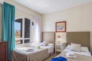 a hotel room with two beds and a window at Villa Isabella by Villa Plus in Corralejo +17 photos