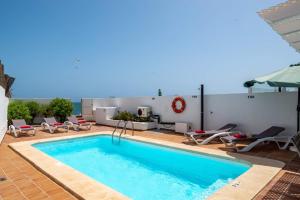 a swimming pool with lounge chairs and a pool at Villa Isabella by Villa Plus in Corralejo