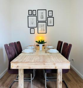 une table à manger avec des chaises et une table avec des fleurs dans l'établissement Ferienwohnung Biesenzeit, à Biesenthal