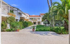 a house with palm trees and a driveway at Resort Miramonti in Forte dei Marmi