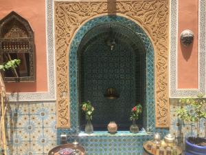 a room with a blue tile wall with vases on a table at Riad Blue Berber in Marrakech