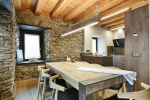 a dining room with a wooden table and chairs at Luderna - Casa Les er Haro in Les