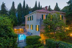 a large house with a swimming pool in front of it at Stone Villa Majestic w Pool - Split Center in Split