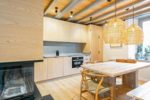 a kitchen with a table and chairs and a fireplace at Luderna - Casa Carboneu in Naut Aran