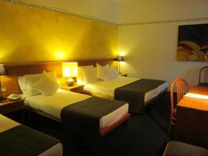 een hotelkamer met twee bedden en twee lampen bij Hotel Marina in Torri del Benaco