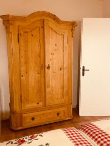 a wooden cabinet sitting next to a bed at Braunegg 1 in Brunico