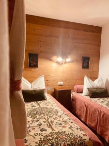 a bedroom with two beds and a wooden wall at Braunegg 1 in Brunico +41 photos
