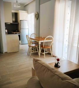 a living room with a table and chairs and a kitchen at Sea & Chess Apt Rental in Chania