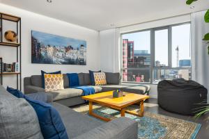 een woonkamer met een bank en een tafel bij Mandela Rhodes Luxury Apartments in Kaapstad