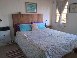 Un dormitorio con una cama grande con cabecero de madera. en Cabaña Acacia Mansa, en Villa Giardino 32 fotos más