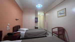 a room with two beds and a chair in it at Hotel Cosmos in Athens