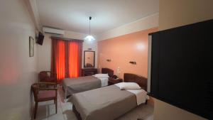 a hotel room with three beds and a television at Hotel Cosmos in Athens