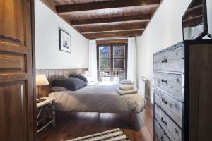 1 dormitorio con 1 cama con tocador y ventana en Luderna - Apartamento Val de Ruda A10 Gerber en Naut Aran