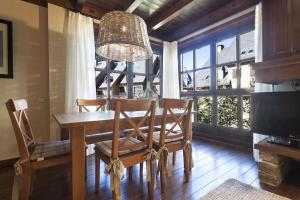 Un comedor con mesa y sillas y una gran ventana. en Luderna - Apartamento Val de Ruda A10 Gerber, en Naut Aran (Alto Arán)