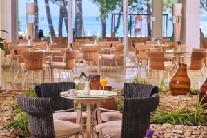ein Restaurant mit Stühlen und Tischen mit Getränken darauf in der Unterkunft Hotel Aurora Plava Laguna in Umag