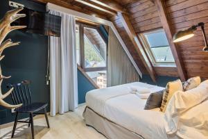 a bedroom with a large bed and a large window at Luderna - Tríplex Val de Ruda E3 der Humarau in Naut Aran