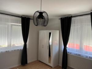 a room with black curtains and a mirror and a chandelier at 4 STARS APARTMENTS Near Airport in Velika Gorica