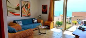a living room with a blue couch and a large window at Apartamento del Mar in Playa Jandia