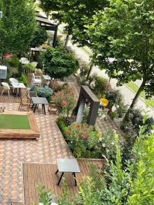 a patio with tables and chairs and flowers and plants at Next Door Park in Skopje