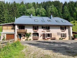 a large house with a metal roof at Gîtes Sous Les Loges in Lélex