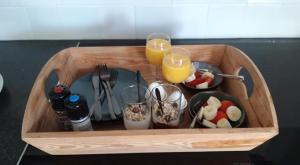 uma bandeja de madeira com comida e dois copos de sumo de laranja em GRUTSK em Workum