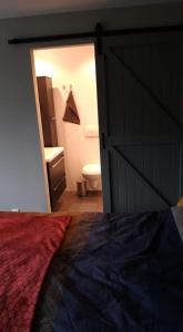 a bedroom with a bed and a bathroom with a toilet at GRUTSK in Workum