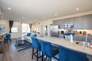a kitchen and living room with a counter and blue chairs at Beach Town Home wHot Tub - Walk to Beaches Downtown Activities and more in Half Moon Bay