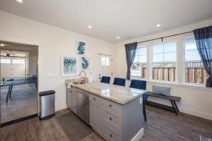 a kitchen with a large island and a living room at Beach Town Home wHot Tub - Walk to Beaches Downtown Activities and more in Half Moon Bay