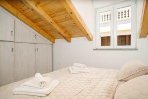 ein weißes Schlafzimmer mit einem Bett mit Handtüchern darauf in der Unterkunft Villa Pia in Vodice